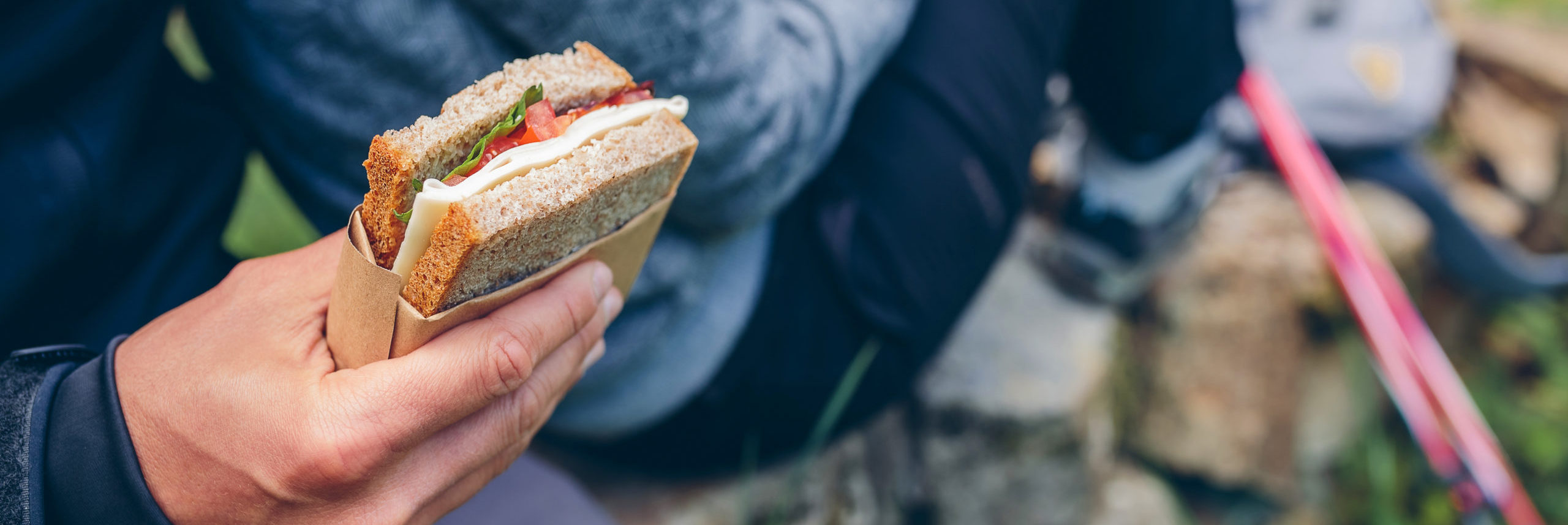 Detail of a sandwich that a couple is going to eat making a break to do trekking