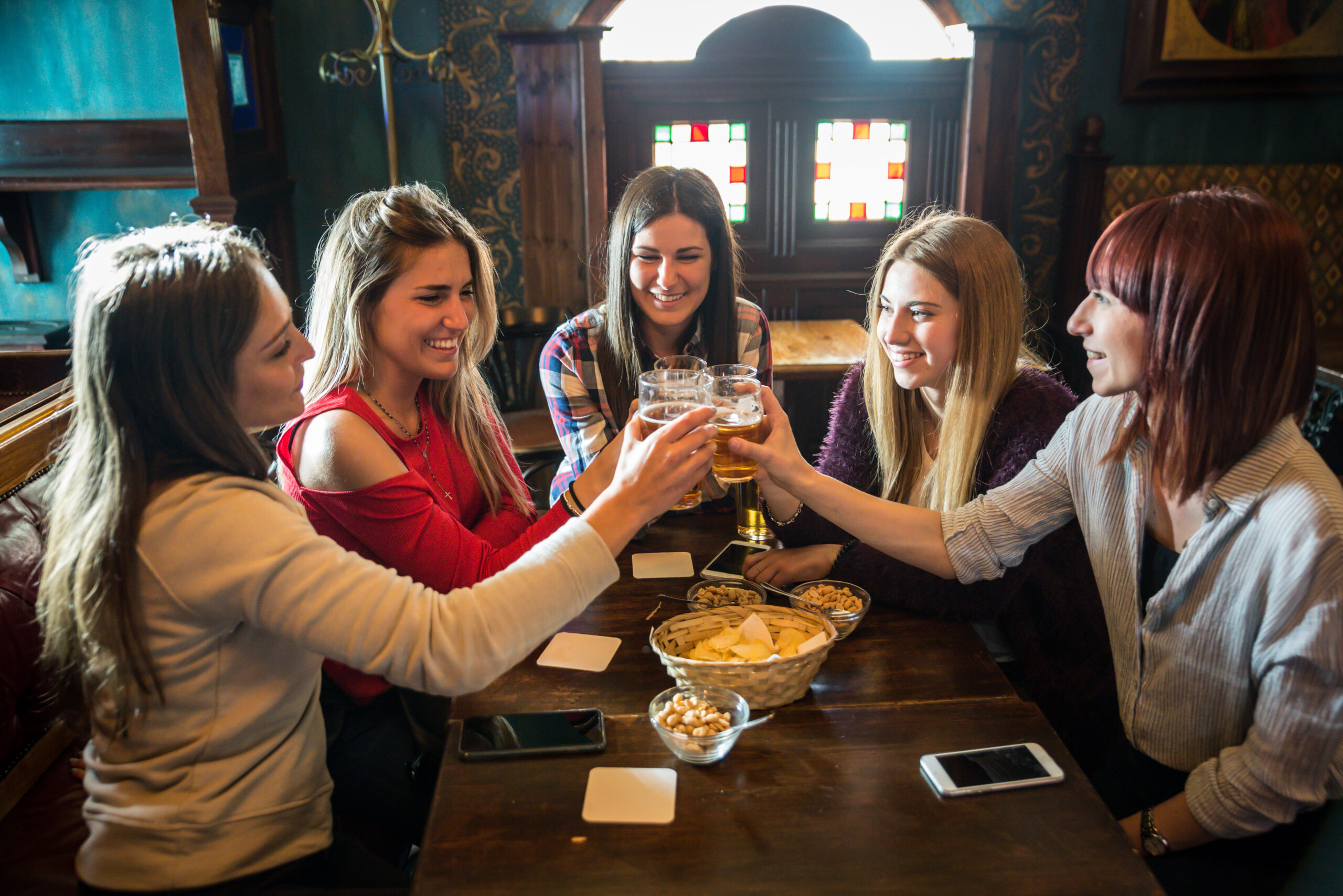 Group of happy friends having party in a bar  - Young people drinking beer